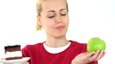 stock-footage-woman-choosing-cake-over-apple-isolated-on-white